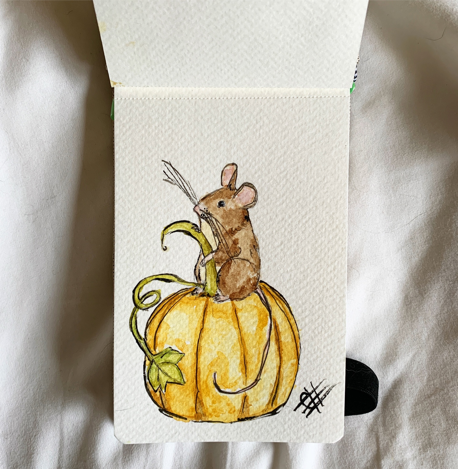 Tiny watercolor mouse sitting on a golden pumpkin